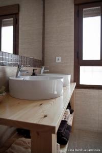 baño con un gran fregadero blanco en una encimera de madera en Casa Rural La Carrascala, en Zamora