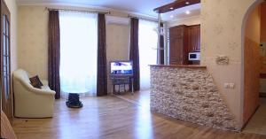 ein Wohnzimmer mit einem TV, einem Sofa und einem Tisch in der Unterkunft Park Apartment in Lwiw