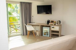 a living room with a desk with a television and a chair at Melia Cartagena Karmairi in Cartagena de Indias