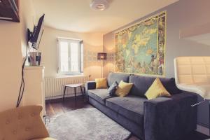 una sala de estar con sofá y una pintura en la pared en La Maison de la Liberté Studio Jules Verne en Poitiers