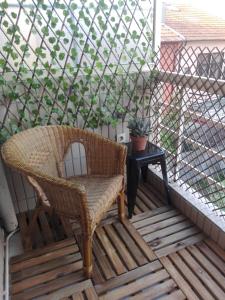 a wicker chair sitting on a porch with a table at Secondlove in Porto