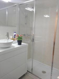 a white bathroom with a shower and a sink at Secondlove in Porto