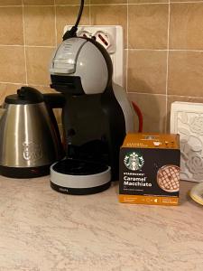 a coffee maker on a counter next to a box of coffee at Gaia's Apartment in Pistoia