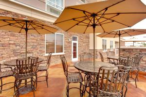 un patio con mesas, sillas y sombrillas en Holiday Inn Hotel & Suites Memphis-Wolfchase Galleria, an IHG Hotel, en Memphis