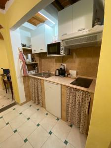 a kitchen with white cabinets and a sink at Gaia's Apartment in Pistoia