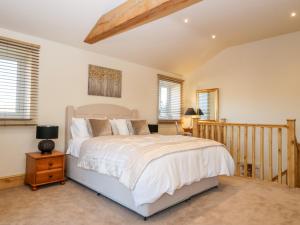 a bedroom with a large bed and a wooden staircase at The Hayloft in Harrogate