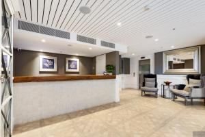 a lobby with a bar and two chairs at Miramare Gardens Boutique Accommodation in Terrey Hills