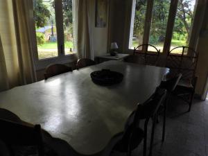 mesa de comedor con sillas y ventana grande en Shanti-om en Sierra de la Ventana