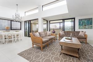 uma sala de estar com um sofá e uma mesa em Miramare Gardens Boutique Accommodation em Terrey Hills