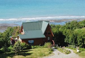 een huis op een heuvel met de oceaan op de achtergrond bij Alaska Adventure Cabins in Homer