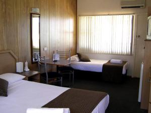 A bed or beds in a room at Koala Tree Motel
