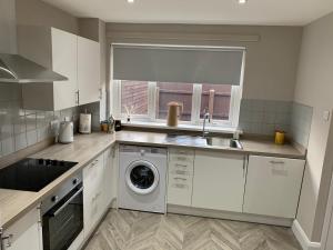 a kitchen with a sink and a washing machine at Weekend City Break Plush Pad in Belfast