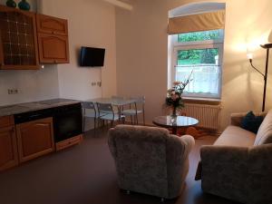 a living room with a couch and a table at Ferienwohnung West - Alte Schule Sachswitz in Greiz