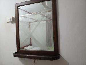 un espejo colgando de una pared con una cortina en Khongaha Villa Holiday Home, en Mirissa