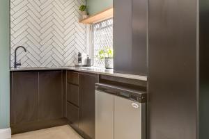 a kitchen with stainless steel cabinets and a window at Gorgeous Beachside Cottage Jervis Bay in Vincentia