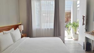 una camera da letto con un letto bianco e una grande finestra di Mantra Gili a Gili Trawangan