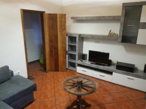 a living room with a couch and a tv at Golden House in Angra do Heroísmo
