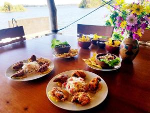 una mesa de madera con platos de comida. en Isleta El Recedo, Entire Island with Personal Staff en Granada