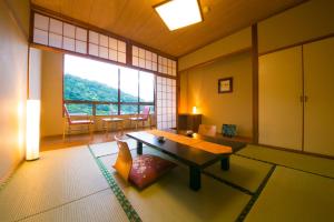 a living room with a table and a large window at Tashiro Annex in Yakushima