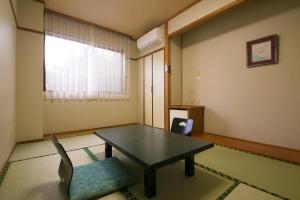 a room with a table and a chair and a window at Tashiro Annex in Yakushima