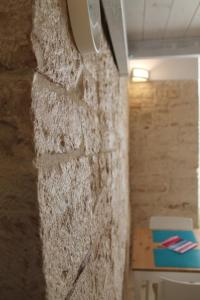 uma parede de pedra num quarto com uma mesa em B&B piazza Garibaldi em Santeramo in Colle