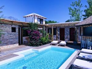 a swimming pool in front of a house at La Posadita in José Ignacio