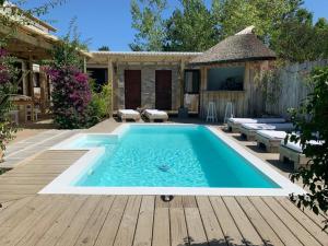 una piscina en un patio trasero con terraza de madera en La Posadita, en José Ignacio