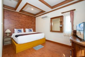 a bedroom with a bed and a mirror and a television at Private Villas Bangtao in Bang Tao Beach