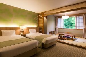 a hotel room with two beds and a window at Midorinokaze Resort Kitayuzawa in Date