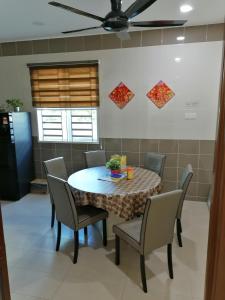 a dining room table with chairs and a ceiling fan at Kkp home stay in Alor Setar