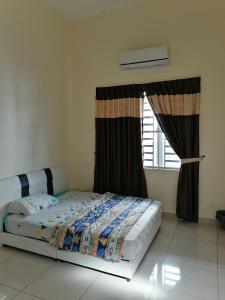 a bed sitting in a room with a window at Kkp home stay in Alor Setar