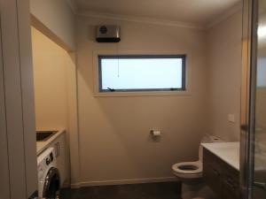 łazienka z toaletą i oknem w obiekcie Sea view new whole holiday house w mieście Kawhia
