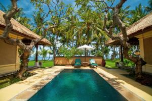 a swimming pool in the backyard of a villa at Puri Bagus Lovina in Lovina