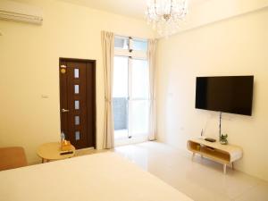 - une chambre avec un lit et une télévision à écran plat dans l'établissement 強國特調民宿, à Taïtung