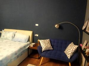 sypialnia z niebieskim łóżkiem i niebieskim krzesłem w obiekcie 悠然宅 w mieście Tainan