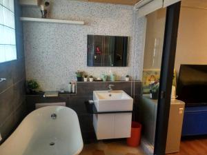 a bathroom with a bath tub and a sink at 悠然宅 in Tainan