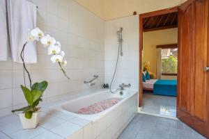 eine Badewanne mit Pflanze im Bad in der Unterkunft Puri Bagus Candidasa in Candidasa
