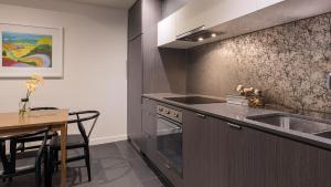 uma cozinha com um lavatório, um fogão e uma mesa em WRAP on Southbank em Melbourne