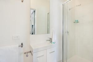 a white bathroom with a sink and a shower at La Costa Beachside Motel in Gold Coast +50 photos