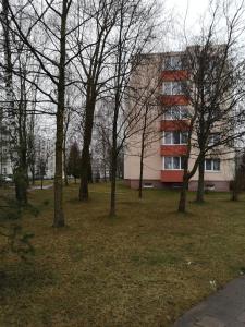 un groupe d'arbres devant un bâtiment dans l'établissement Parko apartamentai, à Panevėžys