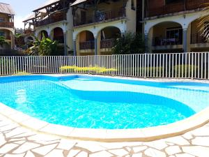 a swimming pool in front of a building at Le Gecko Vert in Manapany-les Bains
