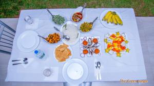 a white table with plates of food on it at The Green Jungle in Dambulla