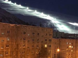 vistas a un gran edificio por la noche con una montaña en 2- х комнатные апартаменты на Олимпийской Зима-Лето en Kirovsk