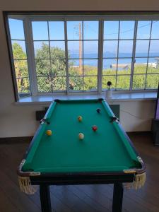 a pool table with balls on it in a room with windows at GANADAN Cottage in Kagoshima