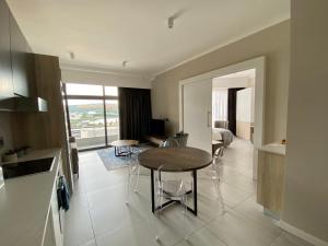 a kitchen and living room with a table and chairs at Menlyn Maine Residence 11th Floor Apartment in Pretoria