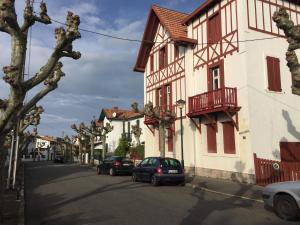 une rue avec des voitures garées sur le côté d'un bâtiment dans l'établissement 2 pièces à 300m de la grande plage - 2 à 5 couchages, à Saint-Jean-de-Luz