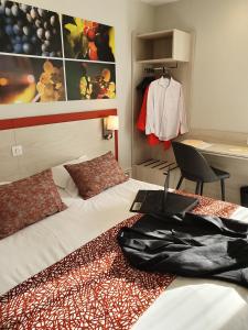 een slaapkamer met een bed met een laptop erop bij Hôtel Saint Louis in Le Thor