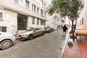 a person walking down a street with parked cars at GREAT APARTMENT 5 MIN TAKSİM SQUARE in Istanbul