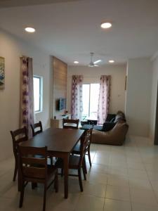 a living room with a table and chairs and a couch at Rose Apartment Keafarm in Cameron Highlands