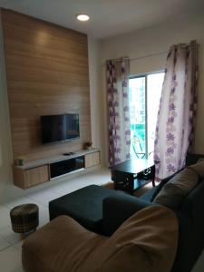 a living room with a couch and a flat screen tv at Rose Apartment Keafarm in Cameron Highlands